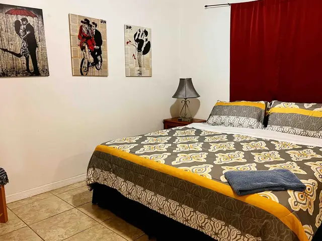 King bedroom with damask bedding and red curtains