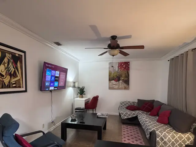 Second view of the Bliss 7 living room with sectional sofa, smart TV and work desk